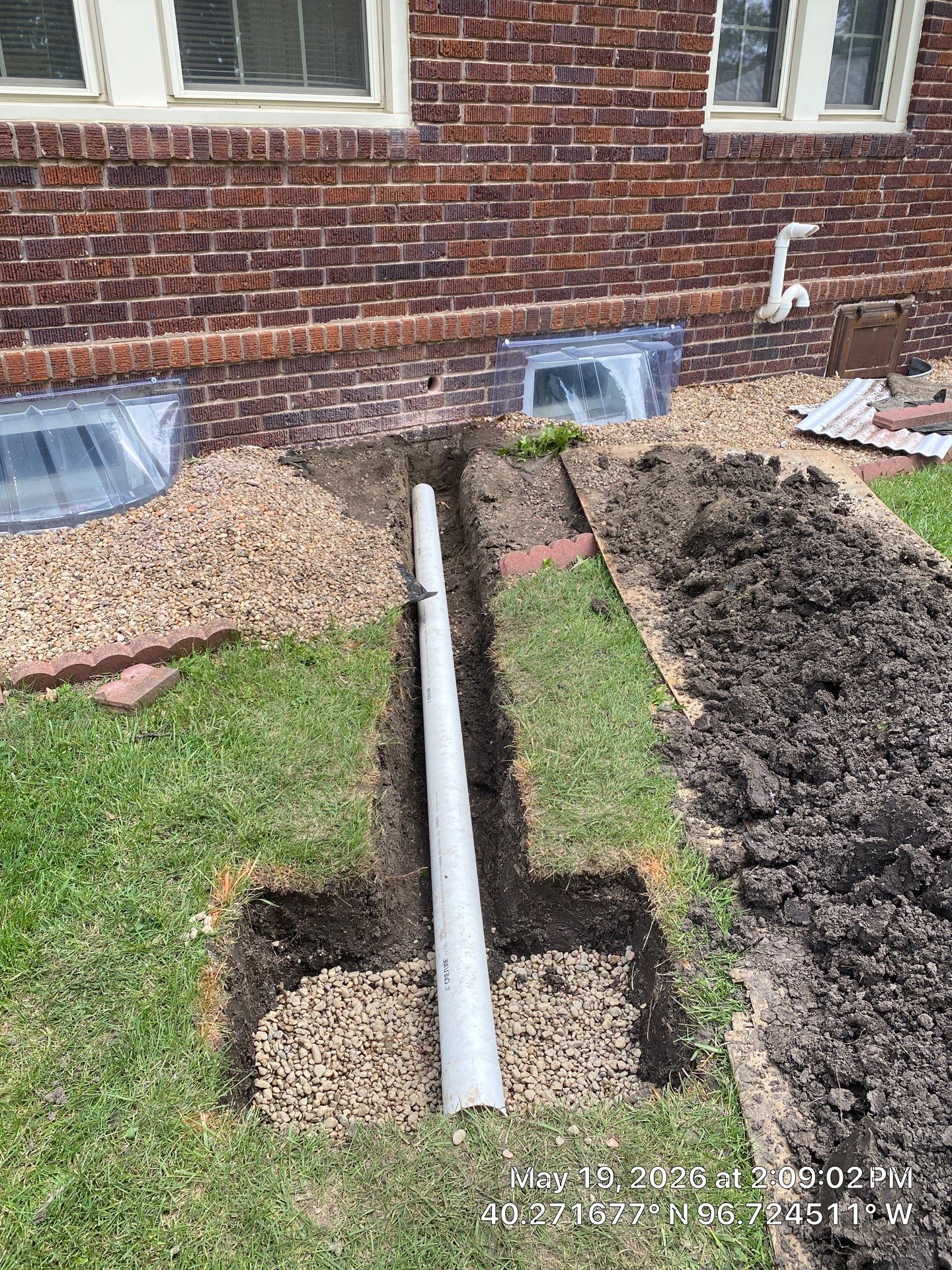 Epp Foundation Repair installs exterior crawl space drainage system with PVC pipe and gravel in a trench in Beatrice, NE.