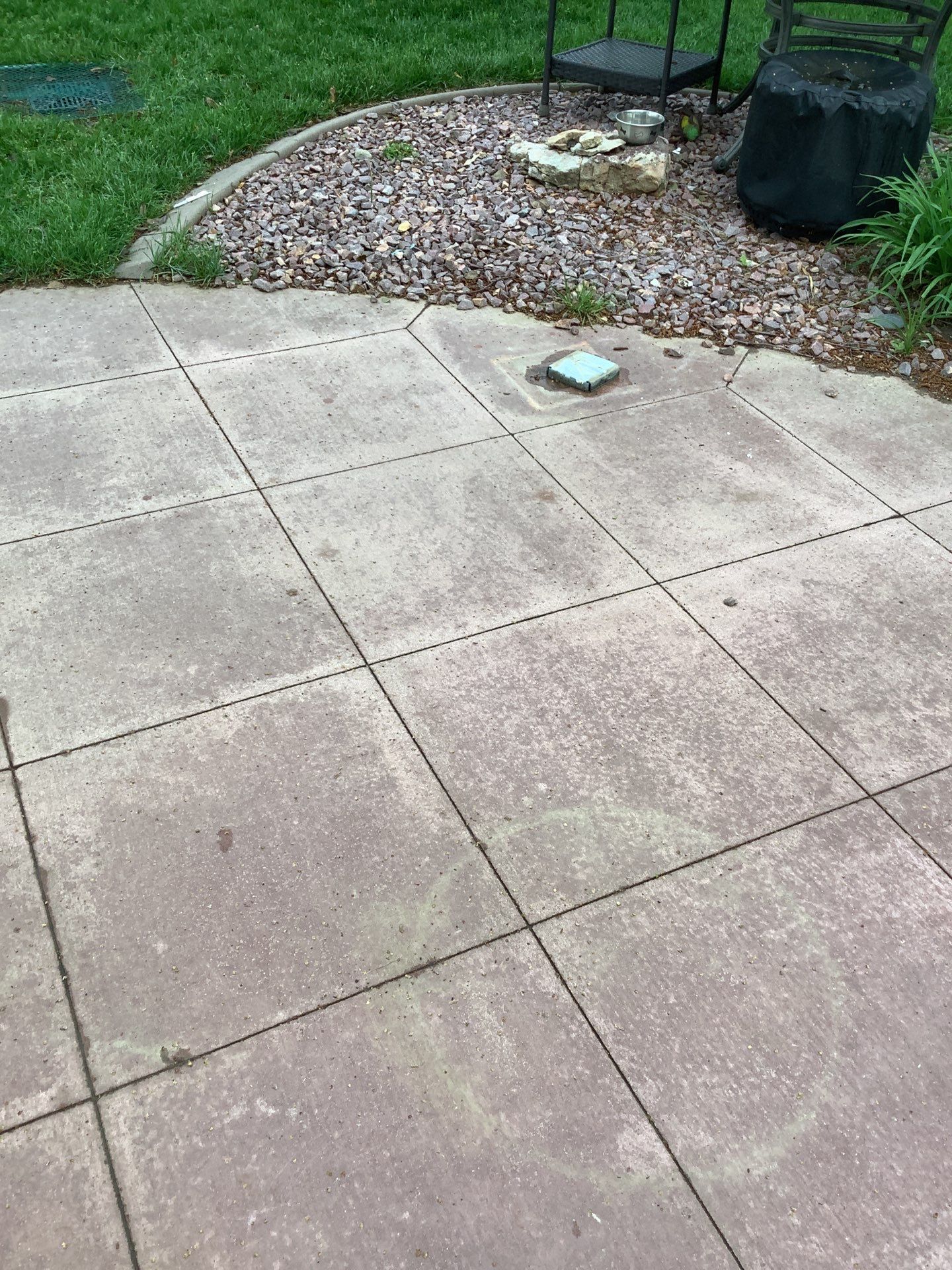 Epp Foundation Repair inspecting uneven concrete patio pavers with chalk marks for repair in Omaha, Nebraska.