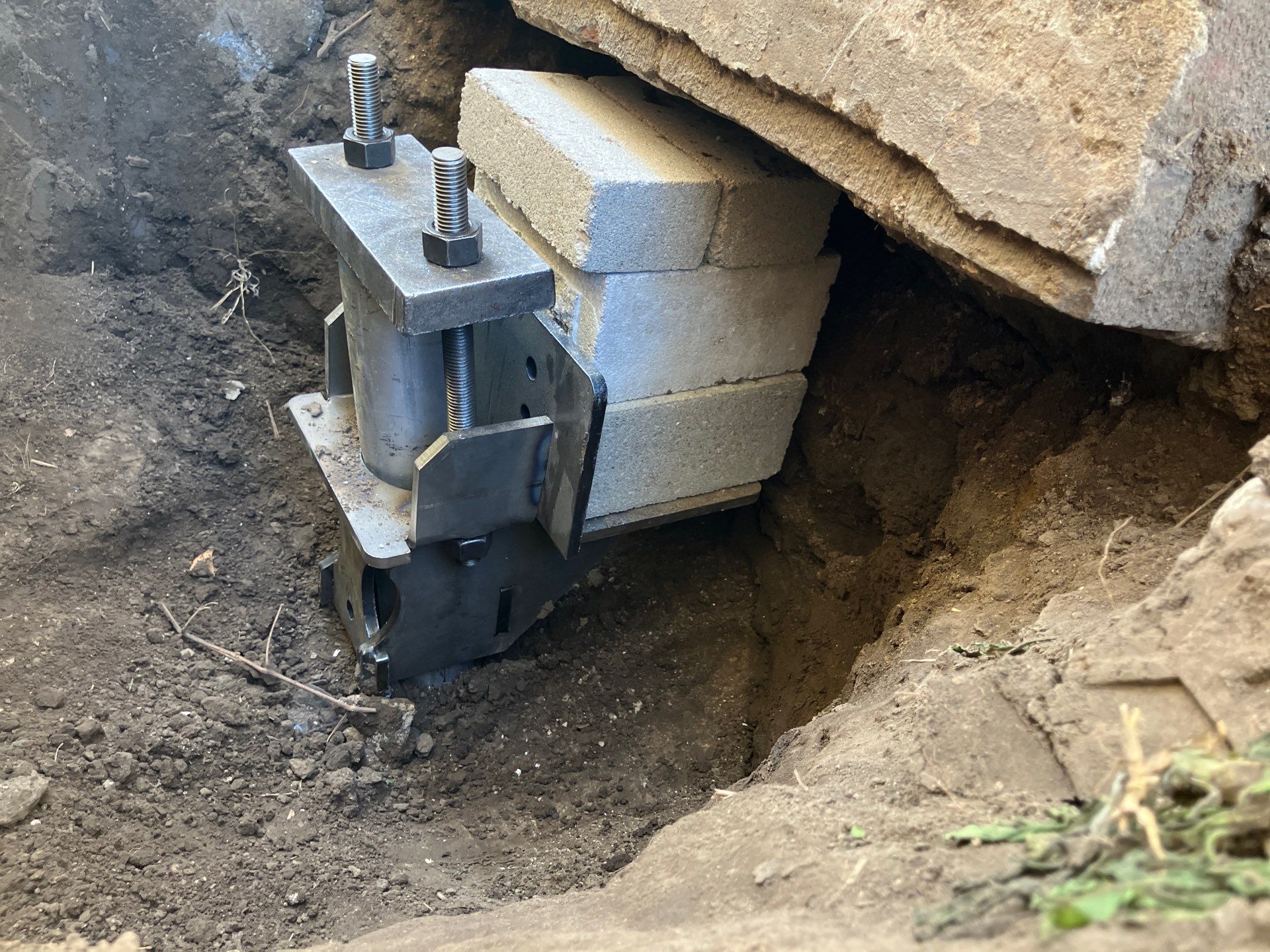 Epp Foundation Repair installing adjustable smart jack for foundation support in excavated area, Des Moines, Iowa.